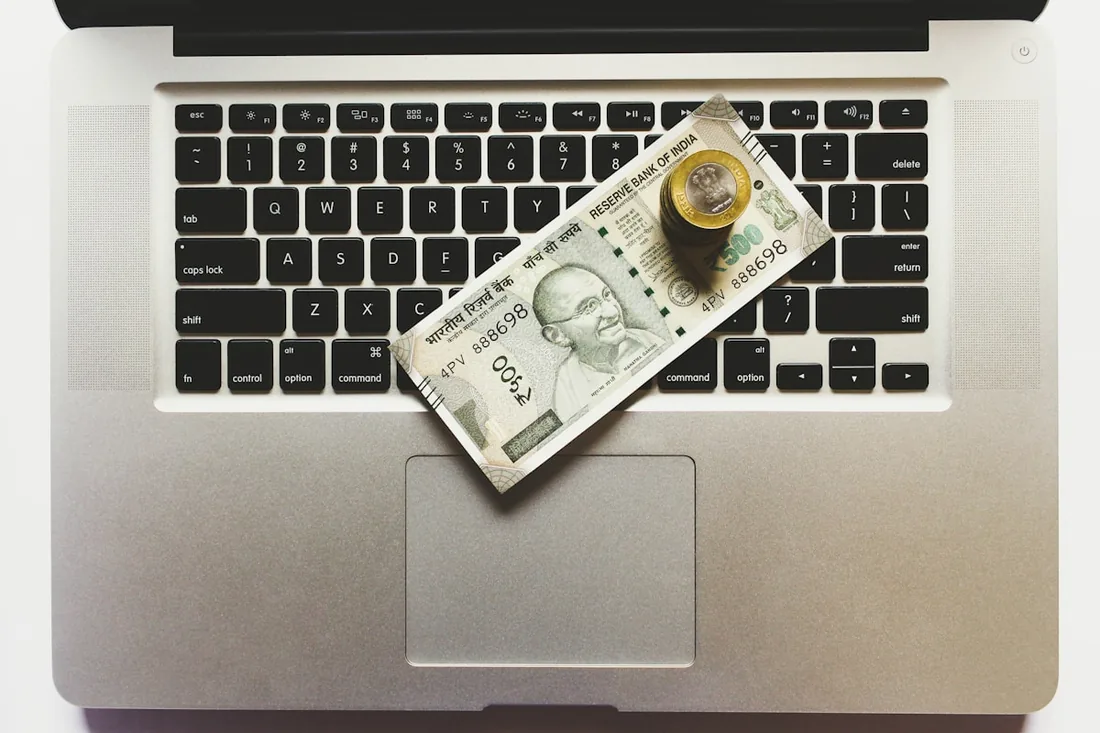Indian rupee notes on a laptop representing virtual office cost savings in Belgaum